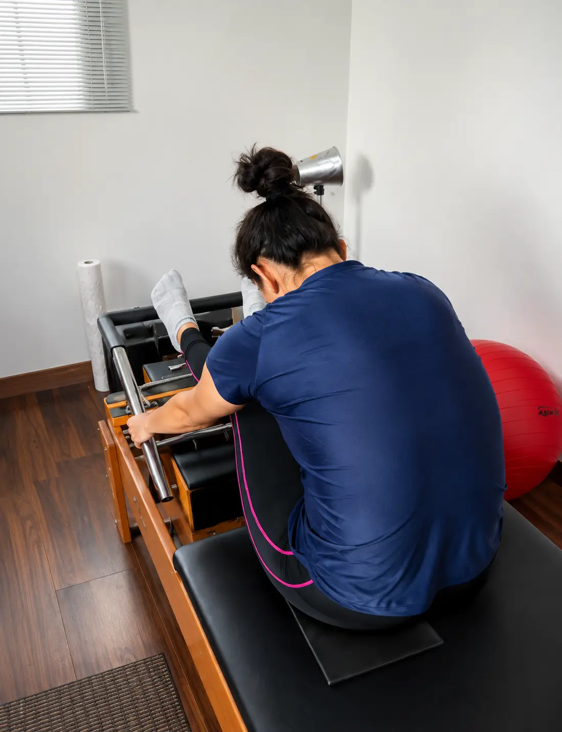 Paciente realizando exercício terapêutico no reformer de Pilates durante sessão individual de fisioterapia