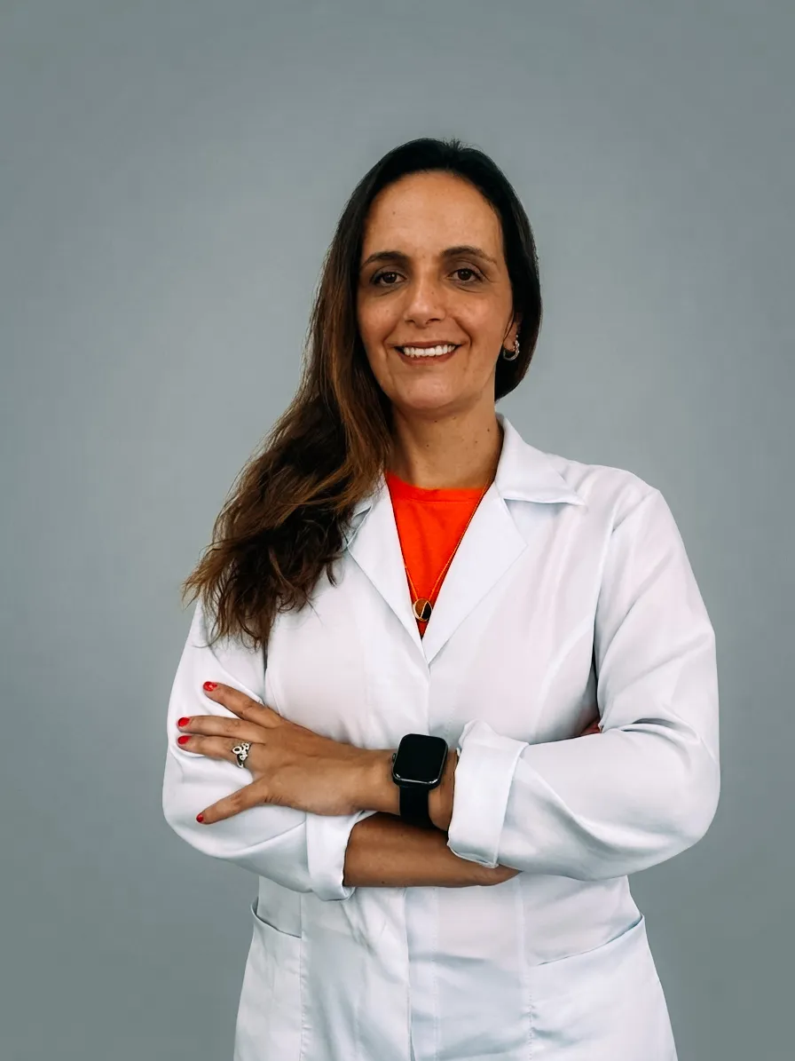 Dra. Thelma Soares, fisioterapeuta, de jaleco branco com os braços cruzados